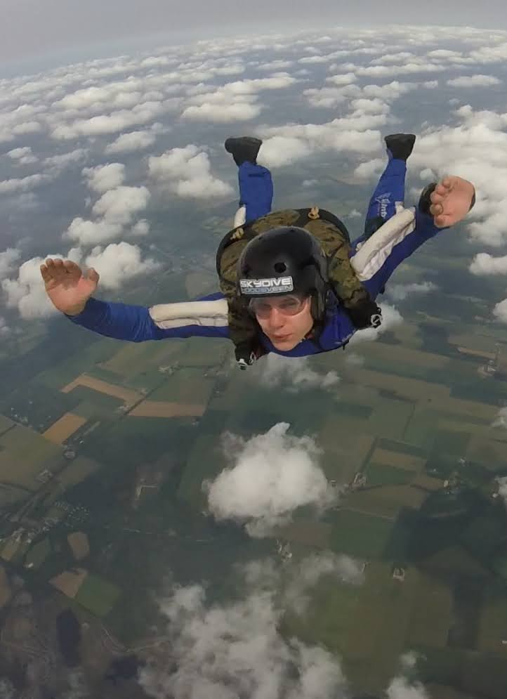 Jonathan mid freefall during a skydive above the Dutch countryside